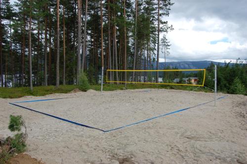 a volleyball net in the sand in front of some trees at Nisser Hyttegrend og Camping in Fjone
