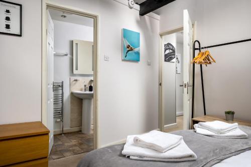 een slaapkamer met 2 bedden, een wastafel en een spiegel bij Curb Properties - Super Apartment Moments From Town Centre in Cheltenham