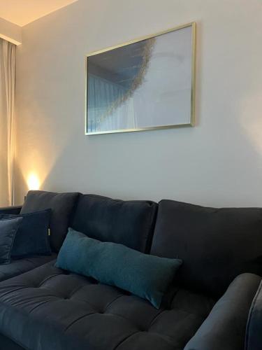 a black couch with blue pillows in a living room at Liz suite in Caesarea