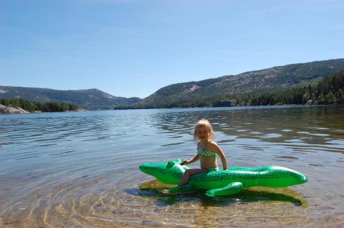 a little girl sitting on a raft in the water at Nisser Hyttegrend og Camping in Fjone