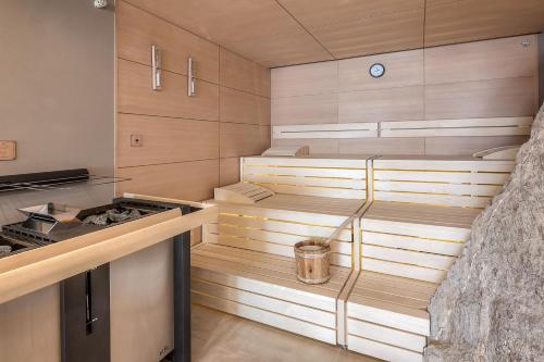 a kitchen with wooden cabinets and a stove at Wellness Aparthotel Panorama Alpin - Ferienwohnungen Jerzens im Pitztal in Jerzens