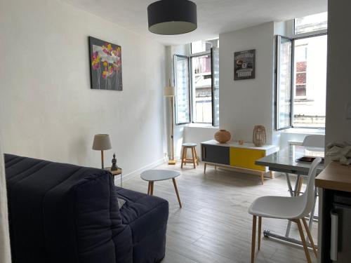 salon z kanapą i stołem w obiekcie L'Oasis Marin meublé, lumineux et cosy à 1min à pied du marché dans l'hyper centre de La Rochelle avec TV et Wifi w La Rochelle