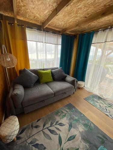 a living room with a couch in front of windows at Chalet de Notre Dame in Le Tampon