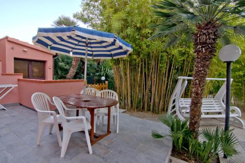 a patio with a table and chairs and an umbrella at Villa Very in Marina di Campo