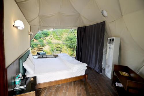 a bedroom with a white bed in a tent at Teela- The Glamping Resort in Udāsar