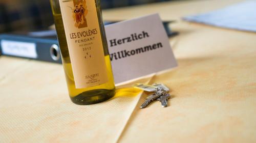 a bottle of wine and a pair of keys on a table at Haus Avalanche in Saas-Fee