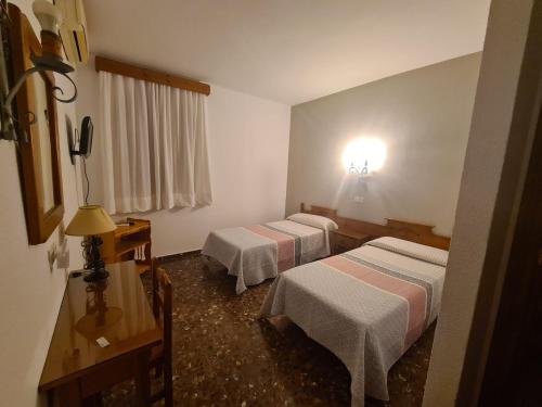 una habitación de hotel con 2 camas y una lámpara en Hotel Restaurante El Lago, en Arcos de la Frontera