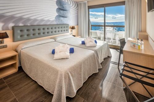 a hotel room with a bed with towels on it at Tropic Park in Malgrat de Mar