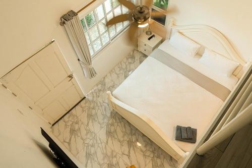 a small room with a bed and a window at ทรายทอง รีสอร์ท in Ban Pru Yai