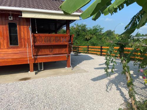 a wooden building with a fence in front of it at Lampang Hideaway Guesthouse in Lampang
