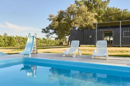 two chairs and a slide next to a swimming pool at MUMA Hotel - Museo de la Madera in Rivera