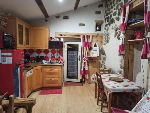 a kitchen with a red refrigerator and a table with chairs at Gîte les coquelicots de Retourtour in Lamastre