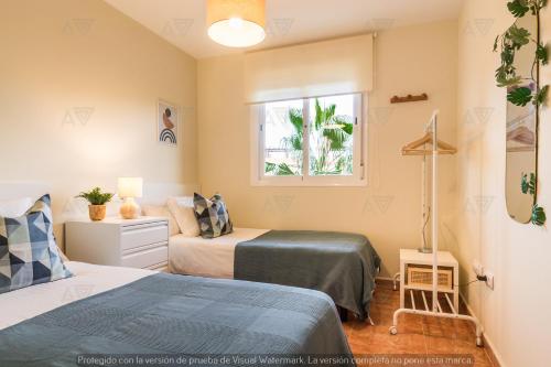 1 dormitorio con 2 camas y ventana en Duplex PARAISO VERA Playa PISCINA PRIVADA en Vera