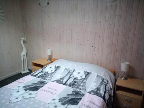 Una cama con edredón en una habitación en Maison Raquet, en Jalhay