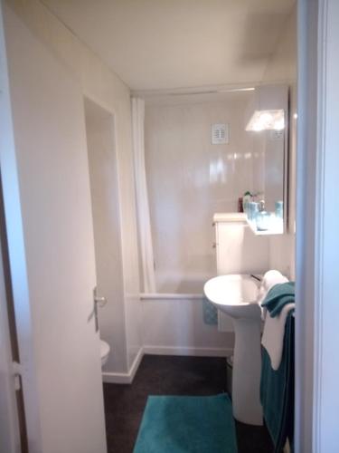 La salle de bains blanche est pourvue d'un lavabo et d'une baignoire. dans l'établissement Maison Raquet, à Jalhay