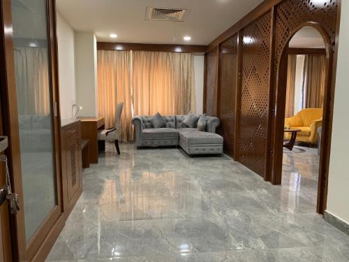 a living room with a couch and a chair at Hotel Hyderabad Grand in Shamshabad