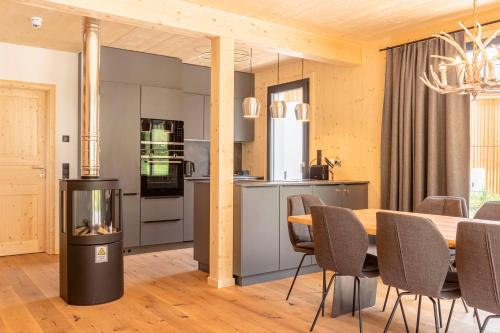 a kitchen and dining room with a table and chairs at Alpenchalets Biberwier Zugspitze by ALPS RESORTS in Biberwier