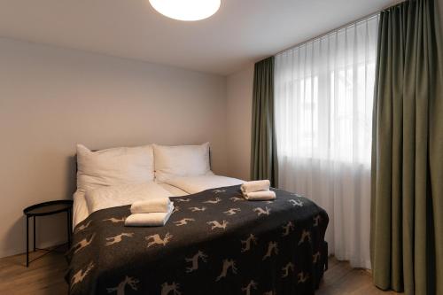 a bedroom with a bed and a large window at Melchtal Resort Apart Hotel in Melchtal