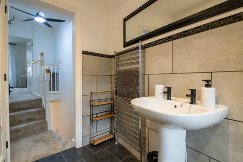 a bathroom with a sink and a walk in shower at Lemon Cottage- Stylish & Modern Home - Town Centre in Newton Abbot