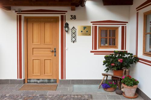 a front door of a house with potted plants at Lienharterhof in Monguelfo