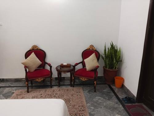 two chairs and a table in a room at 1 Kanal Entire House with 4 Bedrooms in Lahore