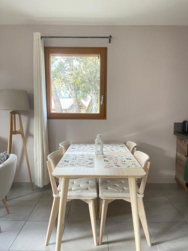 une table et des chaises dans une pièce avec une fenêtre dans l'établissement Appartement au centre de St Martin de Belleville, à Saint-Martin-de-Belleville