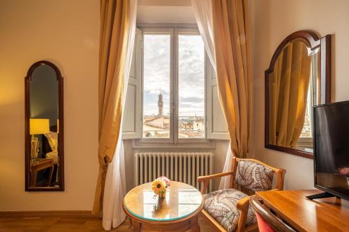 a living room with a table and a window at Hotel Villani in Florence
