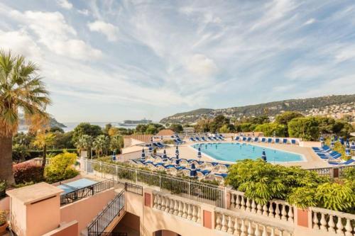 un complejo con una gran piscina con sillas azules en Casa Alessia - Villefranche-sur-mer en Villefranche-sur-Mer