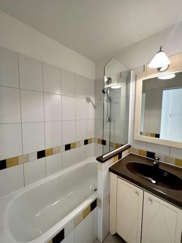 une salle de bain avec un lavabo, une baignoire et un miroir dans l'établissement Casa Alessia - Villefranche-sur-mer, à Villefranche-sur-Mer