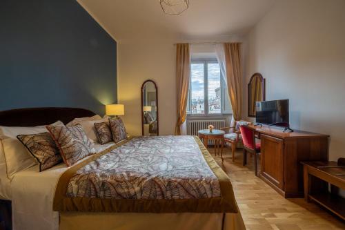 - une chambre avec un lit, un bureau et une télévision dans l'établissement Hotel Villani, à Florence