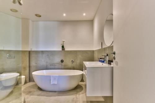 a bathroom with a tub and a sink and a toilet at Two Bedroom Apartment - fully furnished and design in Va Marina Residential in Cape Town