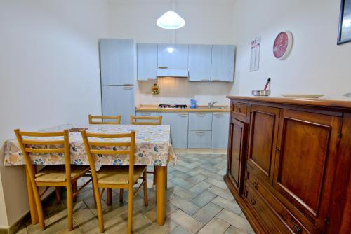 a kitchen with a table and chairs and a kitchen with white cabinets at Villa Very in Marina di Campo