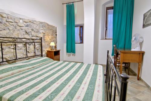a bedroom with a large bed with green curtains at Villa Very in Marina di Campo