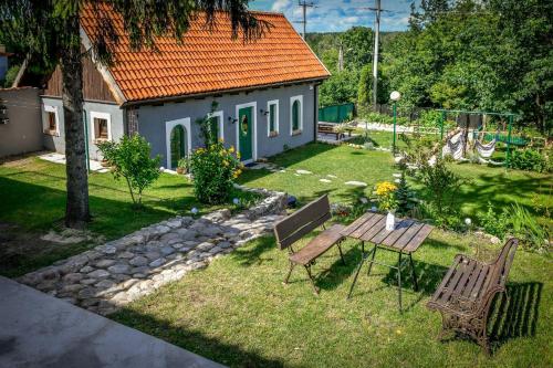 a backyard with a table and chairs and a house at Dawna Apteka Old Pharmacy in Wydminy