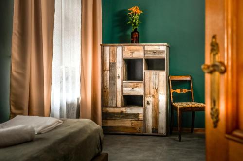 a bedroom with a wooden cabinet and a chair at Dawna Apteka Old Pharmacy in Wydminy