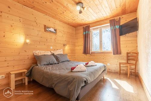 a bedroom with a bed in a wooden cabin at Chalet Le Bois Joli in Bonneval-sur-Arc