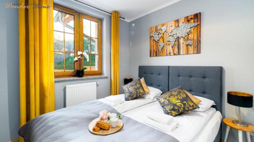 a bedroom with two beds with a tray of food at Wonder Home - Apartamenty położone blisko deptaka, licznych restauracji i sklepów in Karpacz