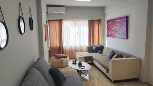 - un salon avec un canapé et une table dans l'établissement Praxitelous CityCenter Modern Apartments by Aesthetic Living, à Athènes