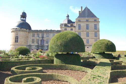 a garden in front of a large building at Appartement LA VIE EN ROSE in Périgueux