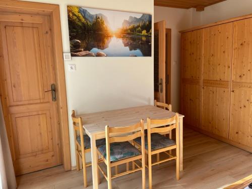 une table et des chaises dans une pièce avec une photo sur le mur dans l'établissement Haus Seerose, à Seeboden