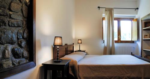 ヴィッジャーノにあるIl Castelluccioの石壁のベッドルーム1室(ベッド1台付)