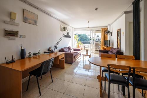 a living room with a table and a dining room at Apollonia Hotel Apartments in Paphos