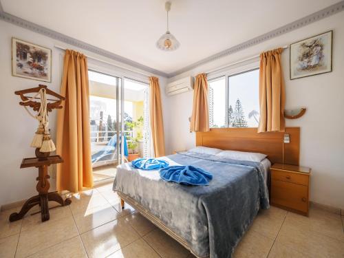 1 dormitorio con cama y ventana grande en Apollonia Hotel Apartments, en Pafos