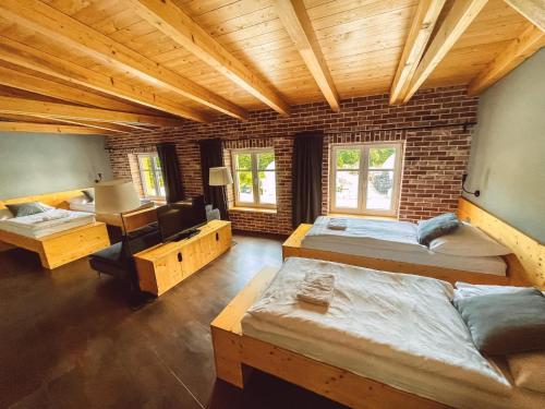 a room with three beds and a brick wall at Pivovar Kocour in Varnsdorf