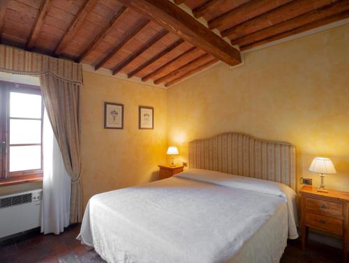 a bedroom with a white bed and a window at B&B Palazzo Al Torrione in San Gimignano