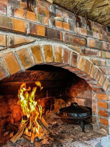 a brick oven with a fire in it at Vila Bašić Vlašić Apartman VUK in Vlasic