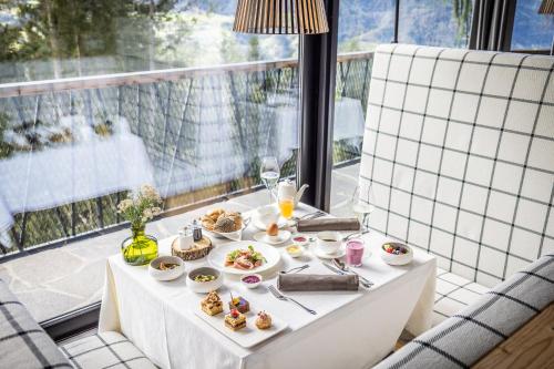 a table with plates of food on a balcony at My Arbor - Plose Wellness Hotel in Bressanone