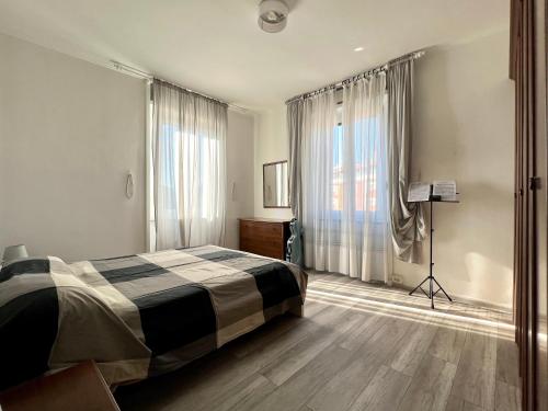 ein Schlafzimmer mit einem Bett und einem großen Fenster in der Unterkunft Il Ritrovo, luminoso trilocale in città in Bergamo