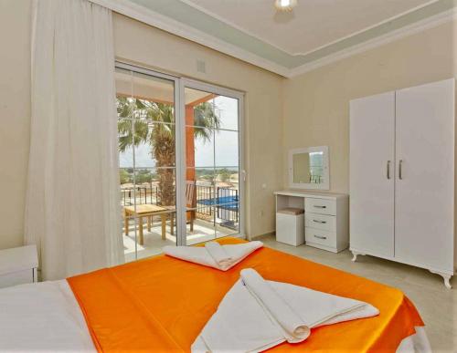 Patara Evleri في باتارا: غرفة نوم بها سرير كبير وبطانية برتقالية