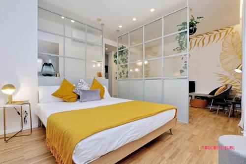 een slaapkamer met een groot bed met gele en grijze kussens bij RENOVATED AND DESIGN FLAT CLOSE TO THE CENTER in Rome